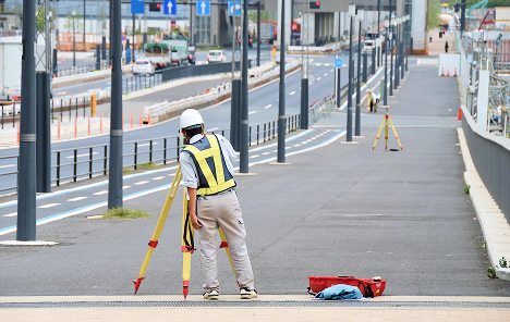 道路上で境界測量をするスタッフ